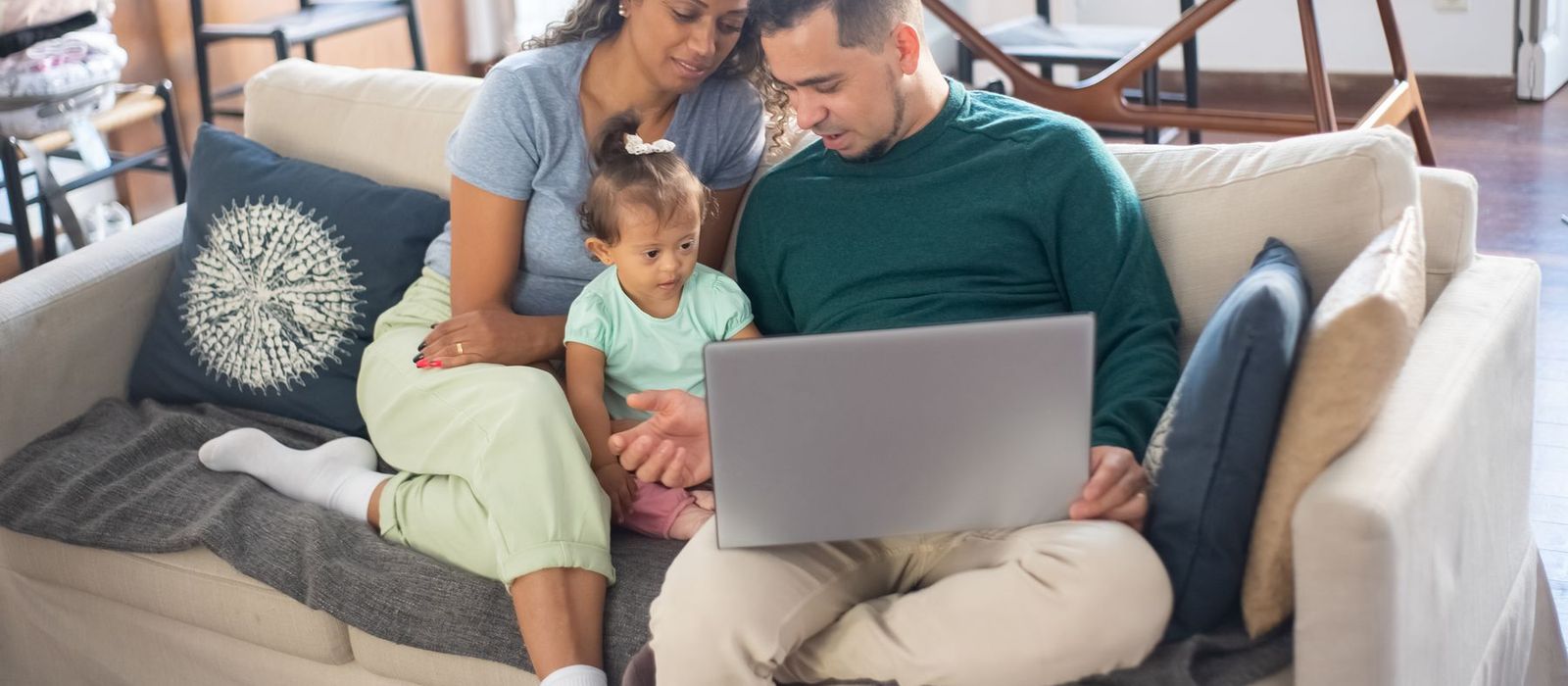 Parents on the sofa with their daughter, going through their plan on a laptop